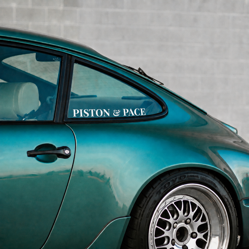 Teal car with 'Piston & Pace' decal on a gray background