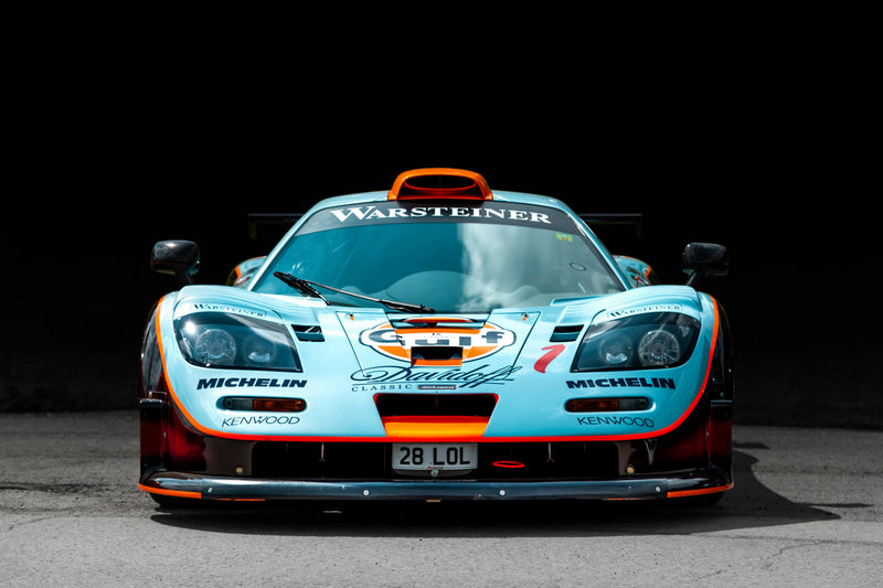 Front view of a race car with visible branding on a dark background