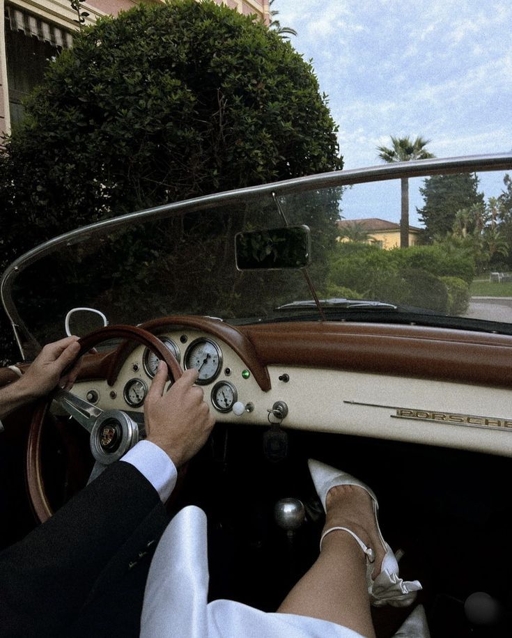Person driving a vintage car with a scenic background